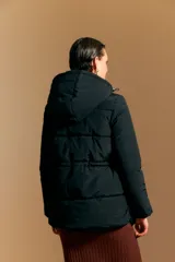 Campera puffer beige con capucha desmontable, cordón ajustable en la cintura, bolsillos laterales y cierre frontal con botones y cremallera.