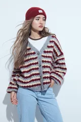 Cardigan de tejido de punto con diseño de rayas horizontales en tonos azul, gris y crema. Presenta escote en V, cierre frontal con botones grandes y mangas largas con puños anchos acanalados.