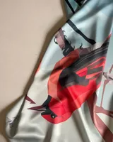 Pañuelo de seda con estampado de pájaros de estilo geométrico en tonos rojo, negro y marrón sobre fondo celeste.