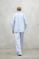 Pantalon de corte relajado y tiro alto, confeccionado en algodon, con pliegues frontales y bolsillos laterales.