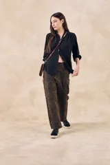 Blusa negra con cuello mao, calce al cuerpo y mangas 3/4 con puños abotonados. Cierre frontal con botones.