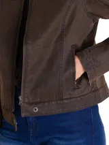 Chaqueta estilo moto de tela encerada color marrón, con cierre frontal metálico, cuello con broche a presión y detalles de costuras reforzadas. Incluye etiqueta con logo en el pecho y cierres en los puños.