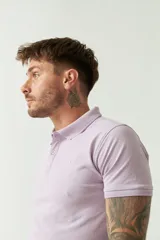 Remera polo blanca de manga corta, con cuello clásico, cierre de tres botones y logo estampado en el pecho.