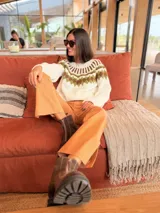 Sweater tejido a mano en mohair, de color marrón con diseño de canesú estampado con corazones fucsias y detalles geométricos en tonos beige y rosado. Presenta cuello redondo y mangas largas.
