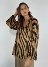 Blusa marrón con estampado animal print de cebra, cuello camisero y mangas largas abullonadas.