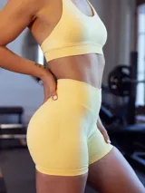 Set deportivo sin costuras color amarillo, compuesto por un top tipo halter con push up removible y un short de tiro alto con control de abdomen.