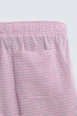 Bermuda de hombre con corte relaxed fit, tiro medio, cintura elástica con botón y cierre de cremallera. Presenta un patrón de cuadros pequeños en tonos rosados y grises.