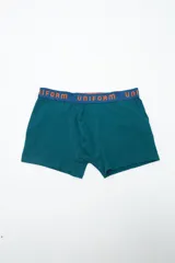 Boxer de algodón color azul francia con elástico en la cintura con la inscripción 'UNIFORM' en color naranja.