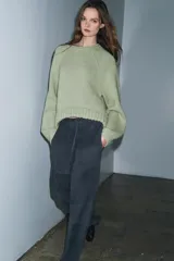 Jersey de punto grueso con cuello redondo, manga larga y diseño de bajo asimétrico.