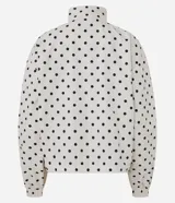 Campera rompeviento deportiva Get Over de microfibra, con estampado de lunares, cuello alto, cierre frontal oculto, bolsillos delanteros con ribete oscuro y puños elásticos.