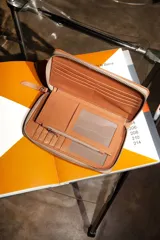 Billetera de cuero color rosa con cierre perimetral. Se abre completamente como un libro, con múltiples espacios para tarjetas, billetes y monedero con cierre incorporado.