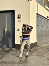 Buzo tejido con diseño de rayas horizontales en tonos marrón, azul, verde y blanco.