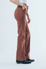 Pantalón de jean tiro alto con corte recto levemente acampanado. Presenta bolsillos delanteros tipo cargo marcados y costuras visibles en color marrón.