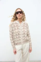 Campera de punto abierta con botones frontales, cuello redondo y mangas largas, con diseño geométrico en tonos crudo y beige.