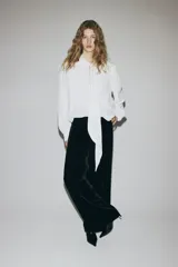 Pantalón de tiro alto de velour negro, de corte recto con pinzas y cintura elástica.