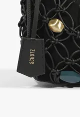 Cartera baguette Schutz de cuero negro con diseño de red trenzada y apliques de cuentas de colores y formas variadas tanto en el cuerpo como en la manija. Incluye llavero colgante con la marca grabada.