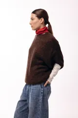 Sweater de tejido de punto grueso con silueta amplia y mangas 3/4. Presenta un diseño de calce relajado con cuello redondo y textura voluminosa.