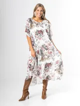 Vestido midi de gasa blanca con estampado floral chintz en tonos rosa y gris, de corte amplio y liviano.