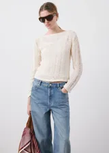 Jeans de tiro medio en denim azul con lavado medio, corte recto y amplio, diseño clásico de cinco bolsillos y cierre frontal con botón y cremallera.