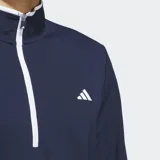 Buzo de golf Adidas azul marino con medio cierre frontal blanco, cuello alto y puños con ribete blanco. Logo de Adidas bordado en el pecho.