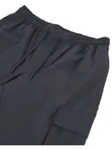 Pantalón cargo Under Armour Woven para hombre, color negro, de corte ajustado con bolsillos laterales y logo de la marca en la pierna izquierda.