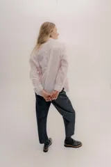 Camisa de manga larga color rosa claro con textura, cuello y puños blancos contrastantes. Los puños tienen tres botones rosados.