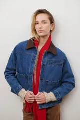 Chaqueta de jean azul con cuello de gamuza color camel, bolsillos delanteros y cierre de botones.