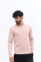 Sweater de punto color rosado, con escote redondo, manga larga y calce regular. Presenta un pequeño logo bordado en el pecho y puños y ruedo acanalados.