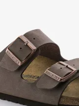 Sandalias Birkenstock modelo Arizona de color marrón con acabado tipo nubuc. Presentan un diseño de dos correas ajustables con hebillas metálicas, base anatómica de corcho y látex, plantilla de ante y suela de EVA.