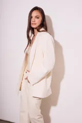 Blazer color crema de poliéster y viscosa, de corte oversize con solapas y doble botonadura.