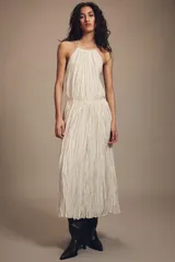 Vestido largo de cuello halter con diseño plisado y textura arrugada. Presenta espalda descubierta con cierre de lazo y cintura elástica.