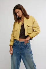 Campera corta de sarga de inspiración workwear, color amarillo con cuello en contraste marrón, bolsillos con solapa en el pecho y cierre frontal con botones.