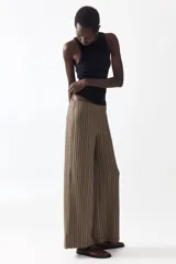 Pantalón de corte holgado en punto con efecto arrugado y diseño a rayas. Modelo con elástico oculto en la cintura y piernas amplias.