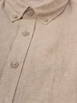 Camisa celeste de lino, de manga larga, con cuello abotonado y bolsillo en el pecho.