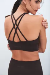 Top deportivo negro de escote redondo y espalda estilo nadadora, con banda elástica inferior para mayor soporte.