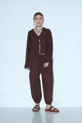 Pantalón abullonado color beige, de tiro alto con cintura elástica y cordón ajustable. Tiene bolsillos laterales y puños elásticos en los tobillos.