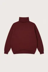 Polera de punto color bordó con cuello alto, diseño de corte holgado y ruedo asimétrico con detalle de costura frontal.