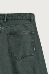 Pantalón barrel fit de mezclilla color verde militar, con efecto lavado, cinco bolsillos, cierre frontal con cremallera y botón, y detalle de pinzas en las rodillas.