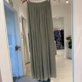 Pantalón ancho color verde agua, confeccionado en tela vaporosa y ligera con acabado satinado, de tiro alto con cintura elástica fruncida y diseño fluido.