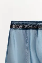Shorts de tiro alto confeccionados en mezcla de viscosa, en color azul con detalles de encaje negro en contraste en la cintura y el ruedo.