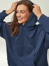 Buzo azul oscuro con capucha, corte oversize, manga larga y bolsillo canguro frontal.