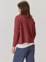 Saco abierto de punto con textura jaspeada en color gris oscuro, con bordes frontales en contraste color marrón. Presenta mangas largas y un corte recto.