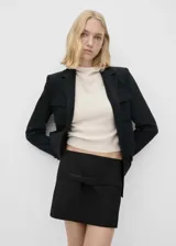 Minifalda negra de corte recto con diseño minimalista, que presenta un cinturón decorativo integrado en la cintura y una sutil abertura frontal.