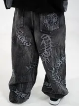 Jean baggy fit de tiro bajo en denim color negro con efecto lavado. Presenta bordados detallados en toda la prenda con motivos orgánicos y abstractos.