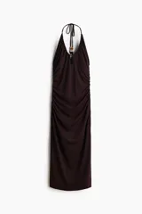 Vestido midi de punto color marrón, con diseño halter, escote pronunciado y frunces laterales que generan un efecto drapeado. Cuenta con cordón ajustable en la nuca adornado con cuentas en los extremos.