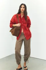 Camisa de corte oversize confeccionada en popelín de algodón, con cuello solapa, manga larga con puños y cierre frontal de botones.