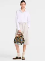 Cartera de red grande Longchamp de la línea Le Pliage Filet Camo, con diseño de red decorado con apliques de flores y solapa con asas de cuero marrón.