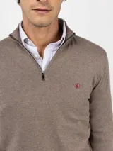 Sweater de punto color verde militar con cuello alto y medio cierre frontal de cremallera, manga larga y detalles acanalados en los puños y el dobladillo.