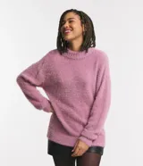 Suéter de punto con textura peluda, cuello redondo y manga larga. Presenta un diseño de corte holgado y acabado suave.