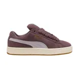 Championes Puma modelo Suede XL, confeccionados en gamuza color violeta con la icónica franja lateral en un tono más claro. Presentan cordones gruesos, suela de goma texturizada en color crema y detalles de la marca en dorado.